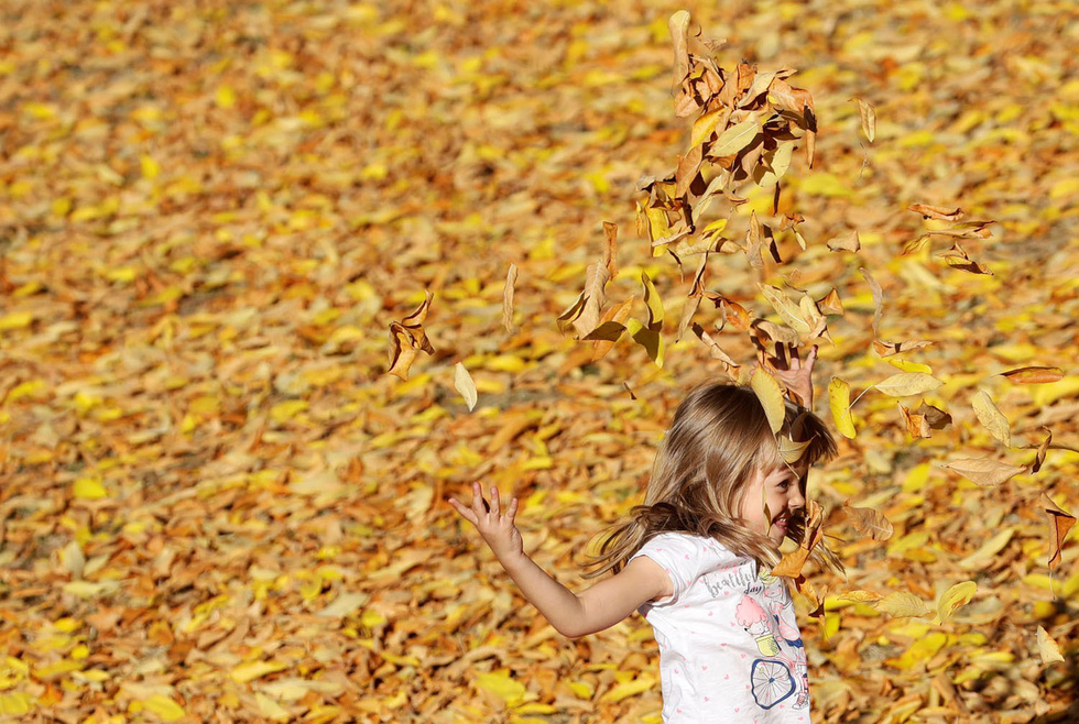 Bé gái chơi đùa trong công viên vào một ngày thu đầy nắng ấm tại thủ đô Prague, Cộng hòa Séc - Ảnh: Reuters/David W Cerny