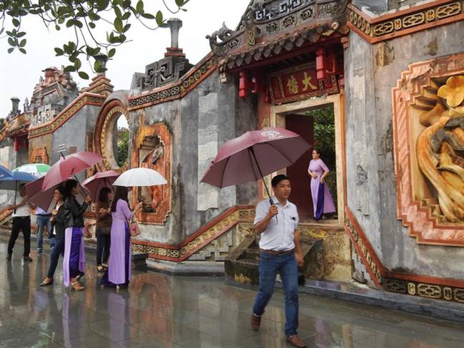 Du khách thích thú tham quan cổng tam quan chùa Bà Mụ vừa đưa vào phục vụ - Ảnh: H.DUY