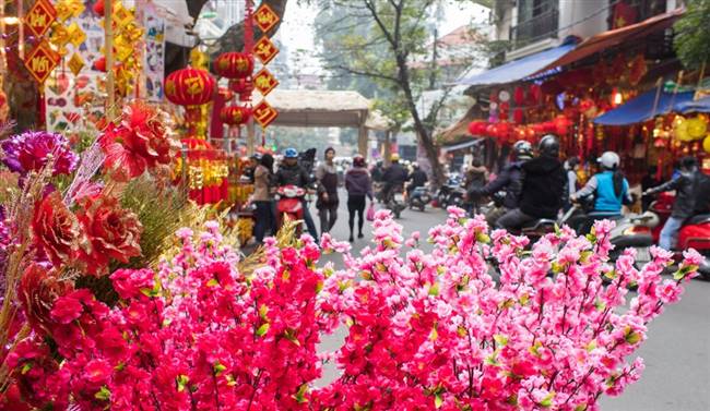 Những con phố ở Hà Nội đỏ rực với hoa đào báo hiệu Tết đã cận kề - Ảnh: ALAMY