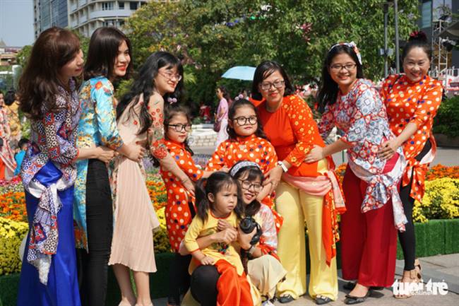 Gia đình bà Hứa Thị Thanh Nga (59 tuổi, Q.10) cùng nhau tạo dáng chụp hình tại đường hoa Nguyễn Huệ - Ảnh: TUYẾT KIỀU