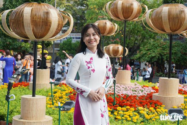 Chị Lâm Ngọc Anh (29 tuổi, Q.Phú Nhuận) yêu thích áo dài truyền thống nên muốn lưu giữ thanh xuân với tà áo dài Việt Nam tại đường hoa Nguyễn Huệ - Ảnh: TUYẾT KIỀU