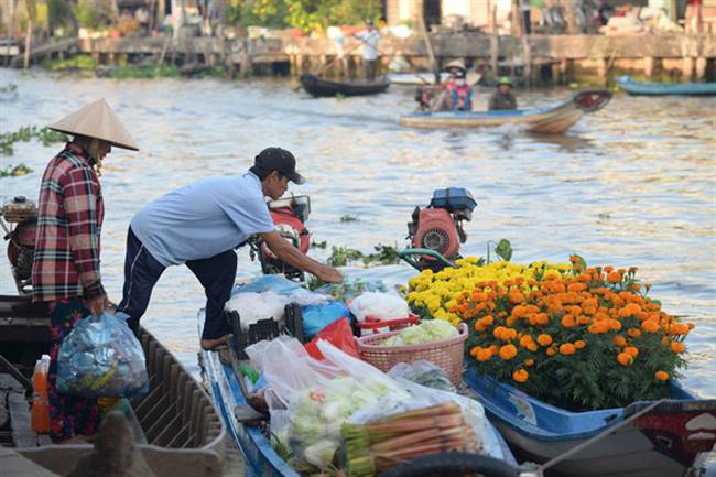 Anh Trần Oanh và vợ đã đến chợ nổi từ 5h sáng để mua hàng đem về kênh 90 bán trong ngày 29 Tết - Ảnh: T.T.D.