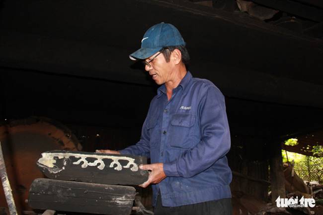 Ông Dương Ngọc Truyền, giới thiệu những khuôn chế tác đồ đồng theo đơn đặt hàng - Ảnh: TRƯỜNG TRUNG