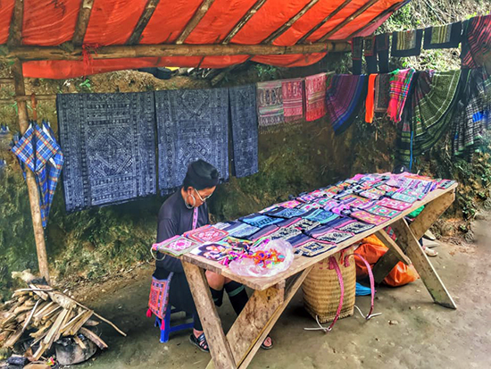Một người phụ nữ Dao bày hàng thổ cẩm dọc theo con đường đến chợ Sapa. Ảnh: X.H