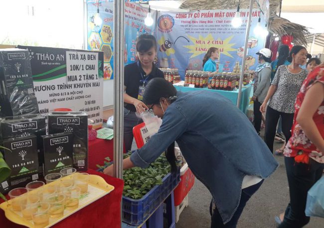 Người tiêu dùng tò mò về cây xạ đen, trong Hội chợ Hàng Việt Nam chất lượng cao vào tháng Ba rồi tại An Giang. Ảnh: Phượng Long Xuyên