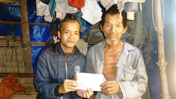 Giang trao tiền từ thiện cho một người khó khăn nghèo khổ - Ảnh: NVCC