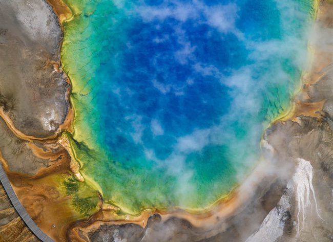 Suối nước nóng Grand Prismatic có đường kính 90 m và sâu 50 m ở công viên quốc gia Yellowstone, Mỹ, được các nhà địa chất phát hiện vào năm 1871. Vào mùa xuân, hồ biến đổi thành một bức tranh đầy sắc màu với cam, đỏ, vàng xanh lá cây hay xanh da trời, do vi khuẩn sắc tố phát triển quanh hồ. Chúng sản sinh nhiều màu sắc khác nhau phụ thuộc vào tỷ lệ chất diệp lục và nhiệt độ của nước.