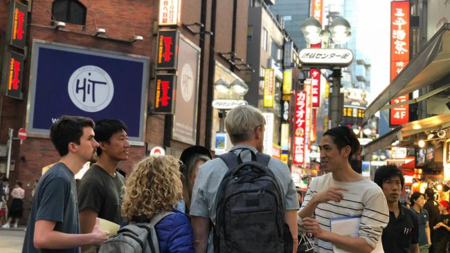 Nomura giới thiệu với khách du lịch về cuộc sống đêm tại Shibuya. Ảnh: NHK