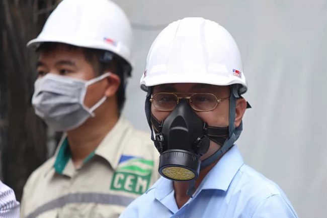 Ông Hoàng Văn Thức (Phó tổng cục trưởng Tổng Cục môi trường, Bộ Tài nguyên và Môi trường) đeo mặt nạ phòng độc thực tế tại nhà kho sáng 31/8. Ảnh: Gia Chính.