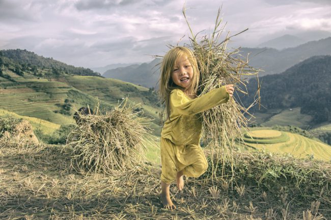 Nụ cười tươi rói của em bé rực rỡ giữa khung cảnh đồng ruộng bát ngát. (Nguồn: Flickr)