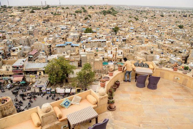 Một người đàn ông ngắm nhìn khung cảnh bên dưới từ pháo đài Jaisalmer, nằm tại thành phố cùng tên ở bang Rajasthan, Ấn Độ. Pháo đài được xây dựng từ năm 1156. Đến nay, công trình vẫn được coi là một trong những pháo đài lớn nhất thế giới. Thành phố Jaisalmer còn được biết đến với tên gọi “Golden City” bởi màu vàng của đá sa thạch phủ khắp thành phố, từ những di sản, công trình lịch sử cho đến nhà dân. Ảnh: Jonathan Kingston.