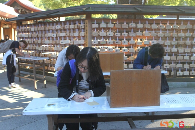Các bạn trẻ đang viết những lời cầu nguyện. Người ta tin rằng những ước nguyện được viết ra, nguyện cầu ở ngôi đền này sẽ sớm được toại ý.
