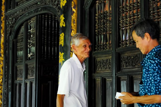 Ông Lê Minh Tồn dẫn khách tham quan nhà cổ trăm cột.