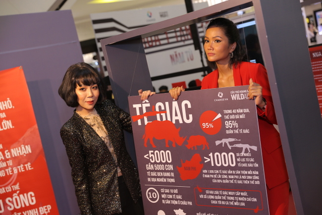 Hoa hậu H’Hen Niê bên cạnh các bảng thông tin liên quan đến chiến dịch “Mua 1 Tặng 15″.