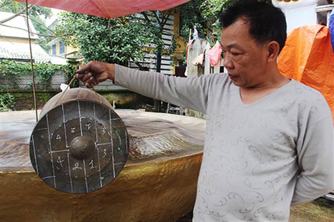 Ông Lê Minh Hiệp chia tỷ lệ trên chiêng nhỏ để làm chiêng lớn. Ảnh: Đắc Thành.