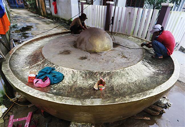 Các nghệ nhân đánh bóng chiêng đồng trước lúc bàn giao cho khách. Ảnh: Đắc Thành.