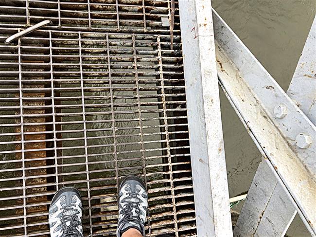 Mặt cầu phía đầu Sài Gòn được làm bằng sắt, lộ những khe hở nhìn xuống dòng sông chảy xiết không dành cho những ai yếu tim.