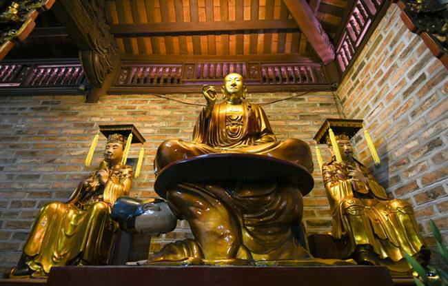 Tượng Phật ngồi lưng vua hay còn có tên gọi khác là Vua sám hối. Theo các nhà nghiên cứu, nguồn gốc của bức tượng bắt nguồn từ thời vua Lê Hy Tông (1663-1716), vị vua thứ 10 của nhà Lê trung hưng. Năm 1678, vua ra sắc lệnh đuổi hết tăng ni lên rừng, ai ngoan cố không rời khỏi kinh thành sẽ bị khép vào trọng tội và đem xử trảm khiến Phật giáo thời kỳ này rơi vào thảm cảnh. Thiền sư Chân Dung Tông Diễn, Tổ thứ hai của thiền phái Tào Động Việt Nam, thấy vậy đã dâng lên vua một chiếc hộp nói là ngọc quý, nhưng thực chất bên trong là một tờ sớ ghi lại những điều lợi cho xã hội mà Phật giáo mang lại. Nội dung bên trong chủ yếu nói về việc “đời Lý, Trần các vua vì hết sức coi trọng đạo Phật mà quốc gia thịnh trị, khiến người ta biết ăn uống đúng mực, không sân si, không giết người cướp của, nó như một viên ngọc quý của quốc gia”.