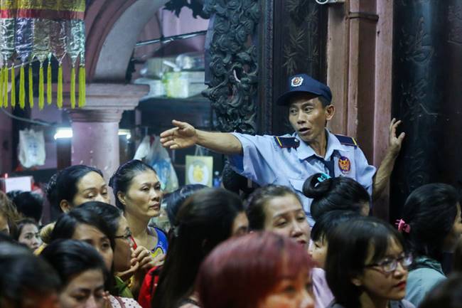 Bên trong khu vực chánh điện đông nghẹt người, ai cũng cố gắng chen chúc nhau làm lễ. Bảo vệ túc trực ở bốn góc nhắc nhở khách hành hương trật tự, xếp hàng, không lễ quá lâu...