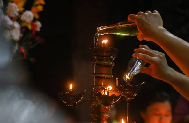"Với người Hoa, việc châm dầu ăn vào đèn mang ý nghĩa tiếp thêm sự suôn sẻ trong mọi điều như công việc, tuổi thọ, sức khỏe... Người cúng sẽ nói tên và điều mình mong cầu trong lúc rót dầu", anh Lý Chí Lâm (37 tuổi) cho biết.