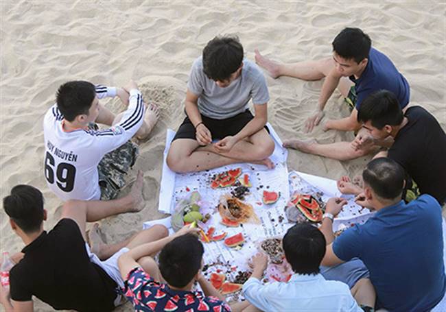 Một nhóm thanh niên tụ tập ăn uống trên bãi biển Mỹ Khê (Đà Nẵng). Ảnh: Nguyễn Đông.