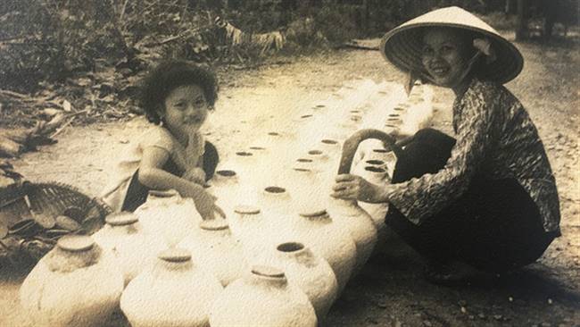 Tác giả - đạo diễn Việt Linh đậy nắp tĩn cùng với mẹ năm 1959 - Ảnh: NSND PHẠM KHẮC