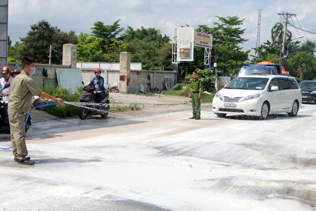 Vôi bột được rải trắng đường ở chốt kiểm dịch trên đường Nguyễn Duy Trinh. Ảnh: Minh Tân.