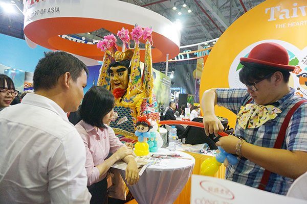 Khách Việt (trái) trong một gian hàng giới thiệu du lịch Đài Loan tại TPHCM.