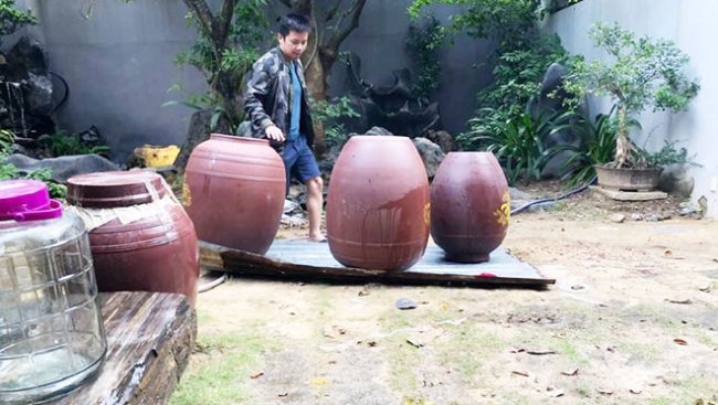 Một người trong hội quán chuẩn bị chum để hạ thổ rượu sâm Ngọc Linh Ảnh: Quang Viên