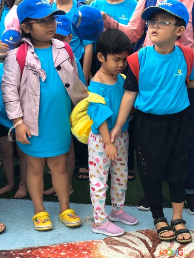 Các em đang xếp hàng chụp ảnh lưu niệm. Hạn chế đôi mắt đã khiến những đôi tay tìm níu nhau để ổn định đội hình. Hàng không thẳng, mỗi người một hướng nhưng vẫn luôn là những bức ảnh đẹp