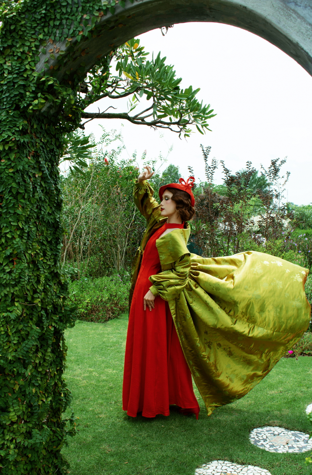 Chiếc đầm đỏ làm nổi bật vẻ sang trọng, quý phái của người con gái Thủ đô, khi được phối cùng với áo khoác gấm xanh mạ non ánh vàng, gợi lên hương cốm thanh tao - món quà mùa thu Hà Nội.