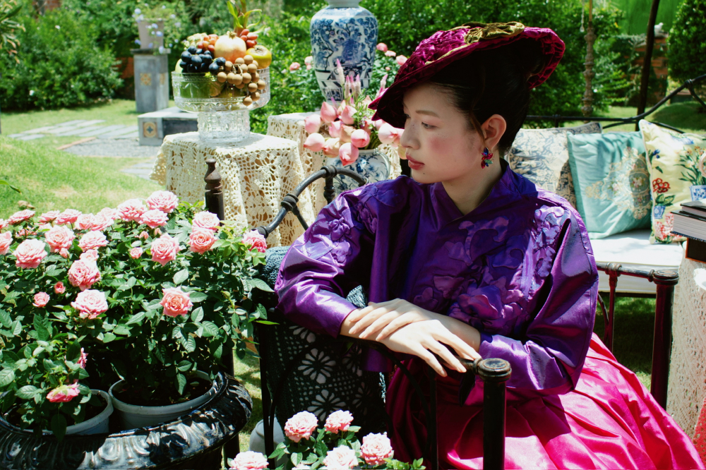 Áo khoác taffeta màu “tím Huế” với vạt trái chồng lên vạt phải theo cấu tạo của áo ngũ thân truyền thống.